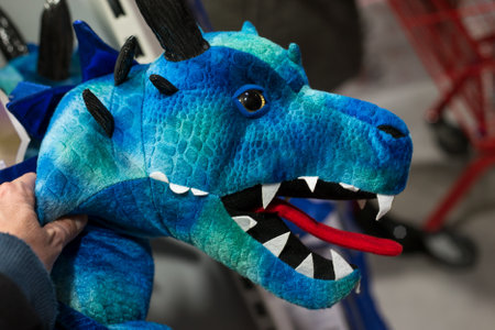 Mulhouse - France - 17 December 2020 - Closeup of blue dinosaur plush in hand in a toys storeのeditorial素材