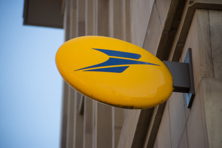 Mulhouse - France - 10 January 2021 - Closeup of the french post logo on agency facadeのeditorial素材