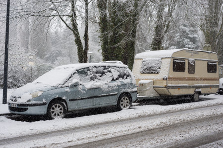 Mulhouse - France - 14 January 2021 - Profil view of blue SUV car and caravan parked in the street durinf Ã  snowfall dayのeditorial素材