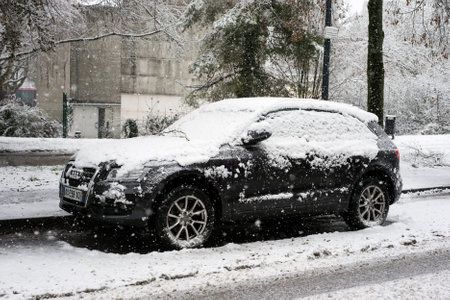 Mulhouse - France - 14 January 2021 - Profile view of black Audi SUV car covered by the snow parked in the street by snowy dayのeditorial素材