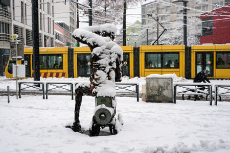 Mulhouse - France 15 January 2021- View of metallic statue and tramway covered by the snow in the street by snowy dayのeditorial素材