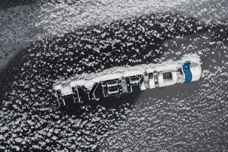 Mulhouse - France - 10 February 2021 - Closeup of Hybrid sign on a black car parked in the street covered by the snowのeditorial素材