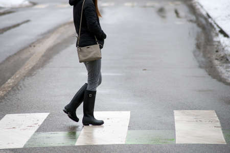 Closeup of legs of young woman crossing the roadの写真素材