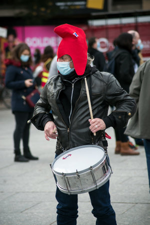 Strasbourg - France - 4 February 2021 - Portrait of man with a revolutionary hat playinf percussion in the streetのeditorial素材