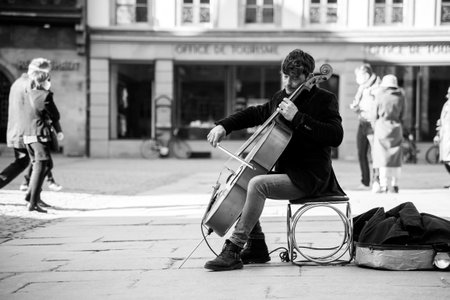 Strasbourg - France - 28 February 2021 - Portrait of musician playing with cello on a cobbles place in front of the cathedralのeditorial素材