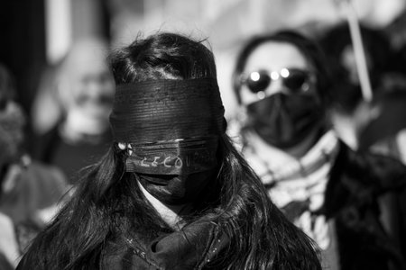 Mulhouse - France - 6 March 2021 - women protesting in the street with black  mask on eyes and medical mask with text in french : coupable, traduction in english : guiltyのeditorial素材