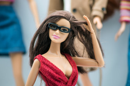 Mulhouse - France - 18 March 2021 - Portrait of realist Barbie doll wearing a sexy red dress posing on dolls colection on backgroundのeditorial素材