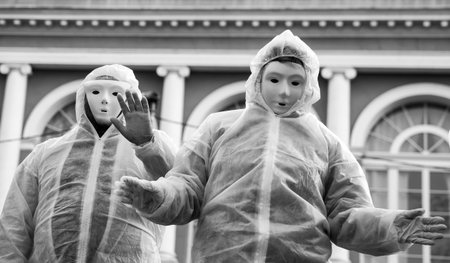 Portrait of people wearing a chemical clothes and carnaval mask  protesting against the sanitary dictatorship , anti masks and anti vaccine people with anonymous  costume in the streetの写真素材