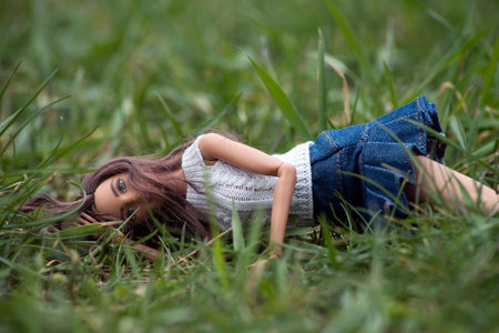 Mulhouse - France - 21 March 2021 - Portrait of brunette Barbie doll lying in the grass in a public gardenのeditorial素材