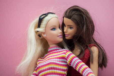 Mulhouse - France - 22 March 2021 - Couple of blond and brunette Barbie dolls wearing colorful clothes posing on pink backgroundのeditorial素材