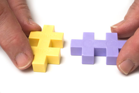 Closeup of plastic construction game in hands on white background