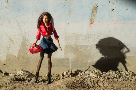 Mulhouse - France - 2 April 2021 - Portrait of brunette Barbie doll wearing a red leather jacket, and blue jean's skirt standing in the streetのeditorial素材