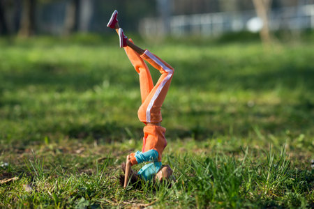 Mulhouse - France - 16 April 2021 - Portrait of brunette Barbie doll wearing orange sportwear practice fitness in a ublic gardenのeditorial素材