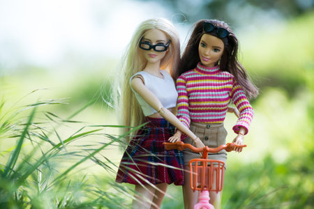 Mulhouse - France - 9 May 2021 - Portrait of two barbie dolls on pink bicycle in a public garden