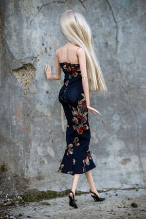 Portrait on back view of blond mannequin doll wearing a black long dress standing in the streetの写真素材