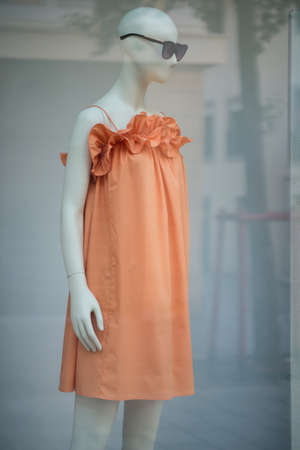 Closeup of orange summer dress on mannequin in a fashion store showroomの写真素材