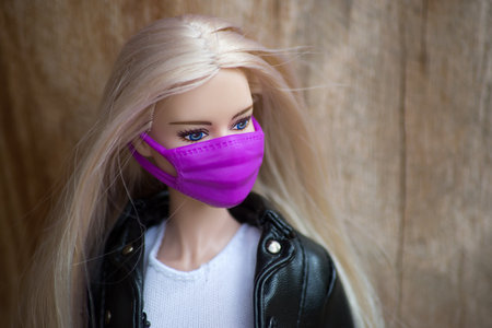 Mulhouse - France - 8 June 2021 - Portrait of blond barbie doll wearing a purple face mask in...