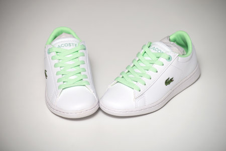 Mulhouse - France - 18 June 2021 - Closeup of white sneakers for kids by Lacoste on white...