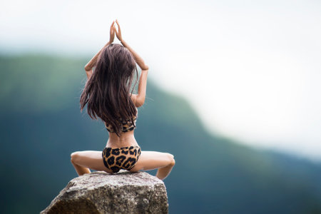 Mulhouse - France - 2 July 2021 - Portrait of brunette barbie doll wearing a printed leopard bikini sitting on rock in border lake in outdoorのeditorial素材