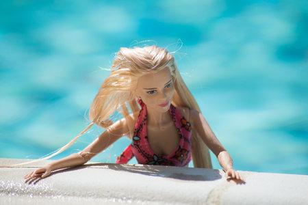 Mulhouse - France - 21 July 2021 - Portrait of blond barbie doll wearing a pink bikini in the swimming pool by sunny dayのeditorial素材