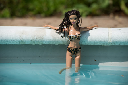 Mulhouse - France - 23 July 2021 - Portrait of brunette barbie doll wearing a printed leopard bikini in the swimming pool by sunny dayのeditorial素材