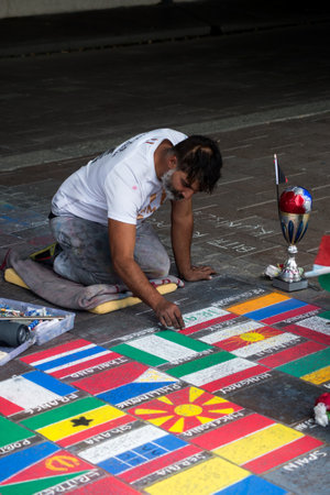 Basel - Switzerland - 6 August 2021 - Portrait of street artist drawing world flags in the streetのeditorial素材