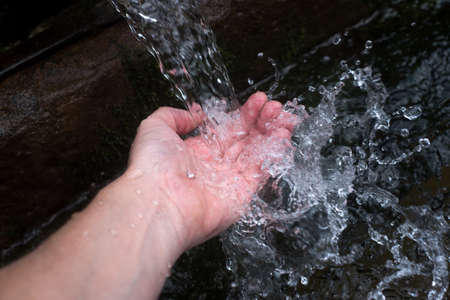 closeup of hands spashing in the water of typical  fountainの写真素材