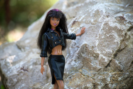 Mulhouse - France - 30 September 2021 - Portrait of black barbie doll wearing a black leather jacket and leather skirt standing in a public gardenのeditorial素材