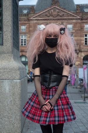 Strasbourg - France - 2 October 2021 - Portrait of sexy girl wearing a school girl costume with shool girl skirt and pink wig in the streetのeditorial素材