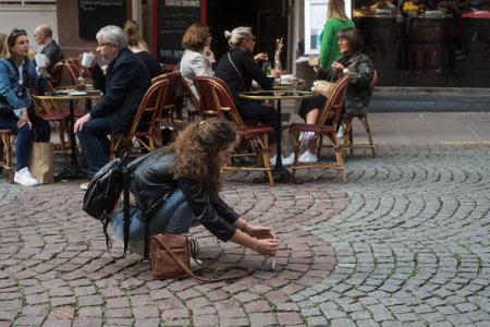 Strasbourg - France - 2 October 2021 -  Portrait of tourist photographer shooting photo with her smartphone in the streetのeditorial素材