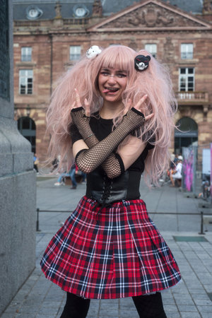 Strasbourg - France - 2 October 2021 - Portrait of sexy girl wearing a school girl costume with shool girl skirt and pink wig in the streetのeditorial素材