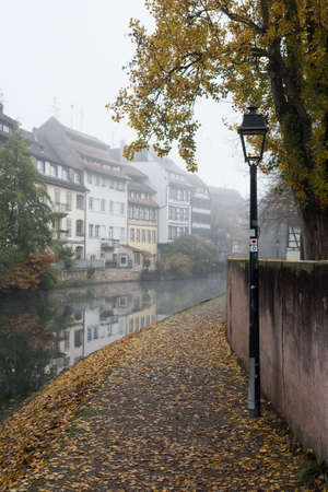 view of autumnal trees in border the Il river at the little france quarter in Strasbourgの写真素材