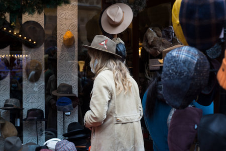Portrait on back view of woman chosing a classic hat at the marketのeditorial素材