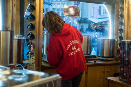 Mulhouse - France - 28 November 2021 -  Portrait of girl giving traditional mulled wine at the christmas marketのeditorial素材