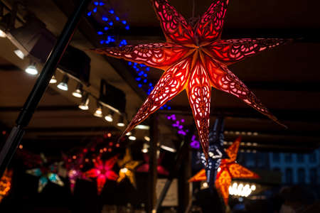 Closeup of christmas lanterns in shaped stars at the christmas marketの写真素材