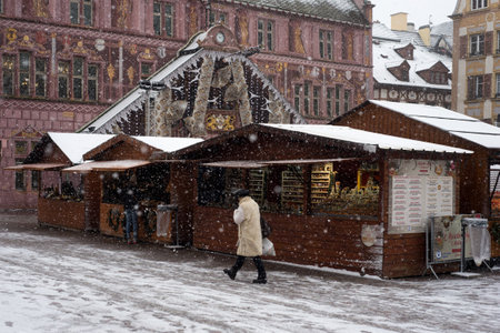 Mulhouse - France - 10 December 2021 - woman wearing a beige winter coat walking at the christmas market by snowy dayのeditorial素材