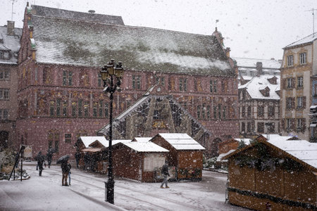 Mulhouse - France - 10 December 2021 - people walking with umbrella at the christmas market by snowy dayのeditorial素材