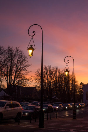Mulhouse - France - 14 December 2021 - View of vintage street lamps and cars traffic on sunset backgroundのeditorial素材