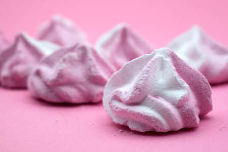 Closeup of meringues on pink background