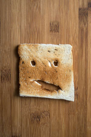 Closeup of expressive toasted slices of bread on wooden cutting board backgroundの写真素材