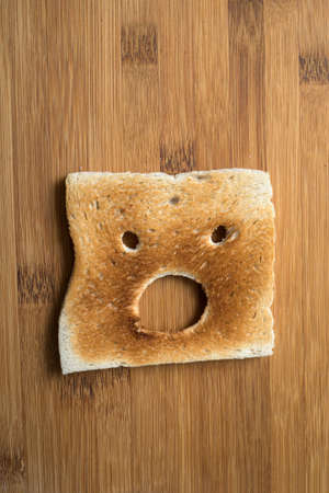 Closeup of expressive toasted slices of bread on wooden cutting board backgroundの写真素材