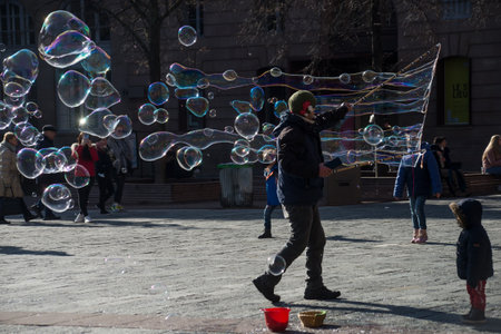 Strasbourg - France - 12 February 2022 - portrait of man playing with soap bubbles with childrenのeditorial素材