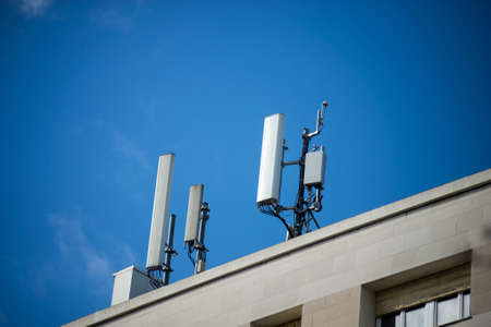 Closeup of telephone antenna relay on the roof of building on blue sky background