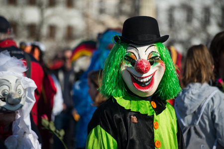 Basel - Switzerland - 9 March 2022 - portrait of masked people wearing traditional costumes of clown parading in the streetのeditorial素材