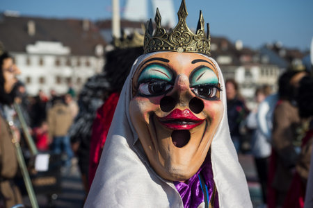 Basel - Switzerland - 9 March 2022 - portrait of masked people wearing traditional costumes of queen with crown parading in the streetのeditorial素材