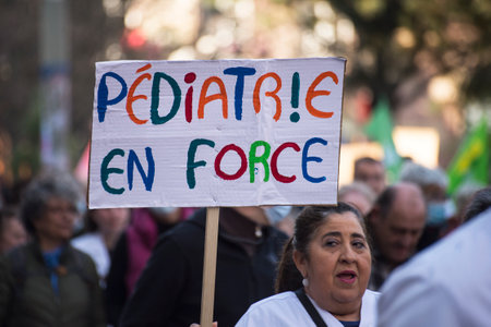 Strasbourg - France - 19 March 2022 - people protesting in the street for the hospital with placard in french : pediatrie en force, in english : strong pediatricsのeditorial素材