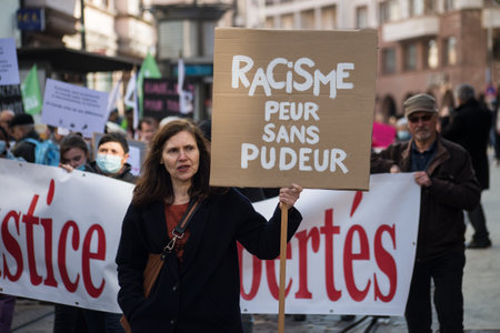 Strasbourg - France - 19 March 2022 - Portrait f people protesting against the racism with placard...