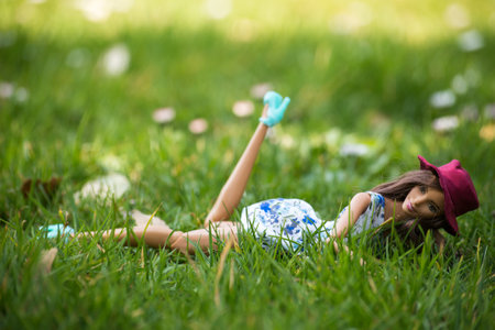 Mulhouse - France - 24 March 2022 - Portrait of brunette barbie doll wearing a blue dress lying in the grassのeditorial素材