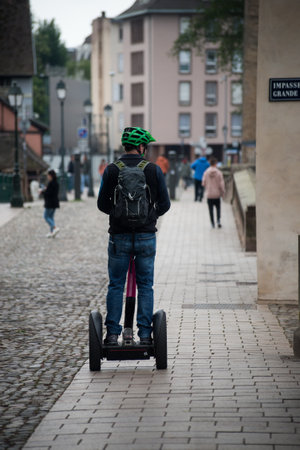 Strasbourg - France - 30 April 2022 - Portrait on back view of man standing on segway in the streetのeditorial素材