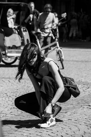 Strasbourg - France - 14 May 2022 - Portrait of young woman tie the laces of his shoes in the streetのeditorial素材